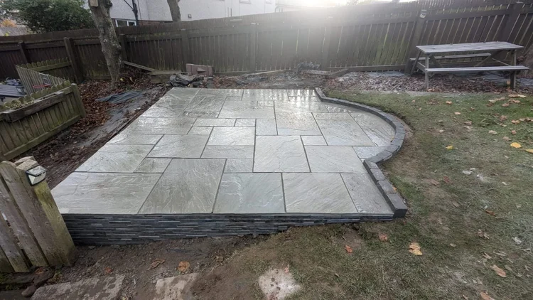 Curved grey sandstone patio on a raised base