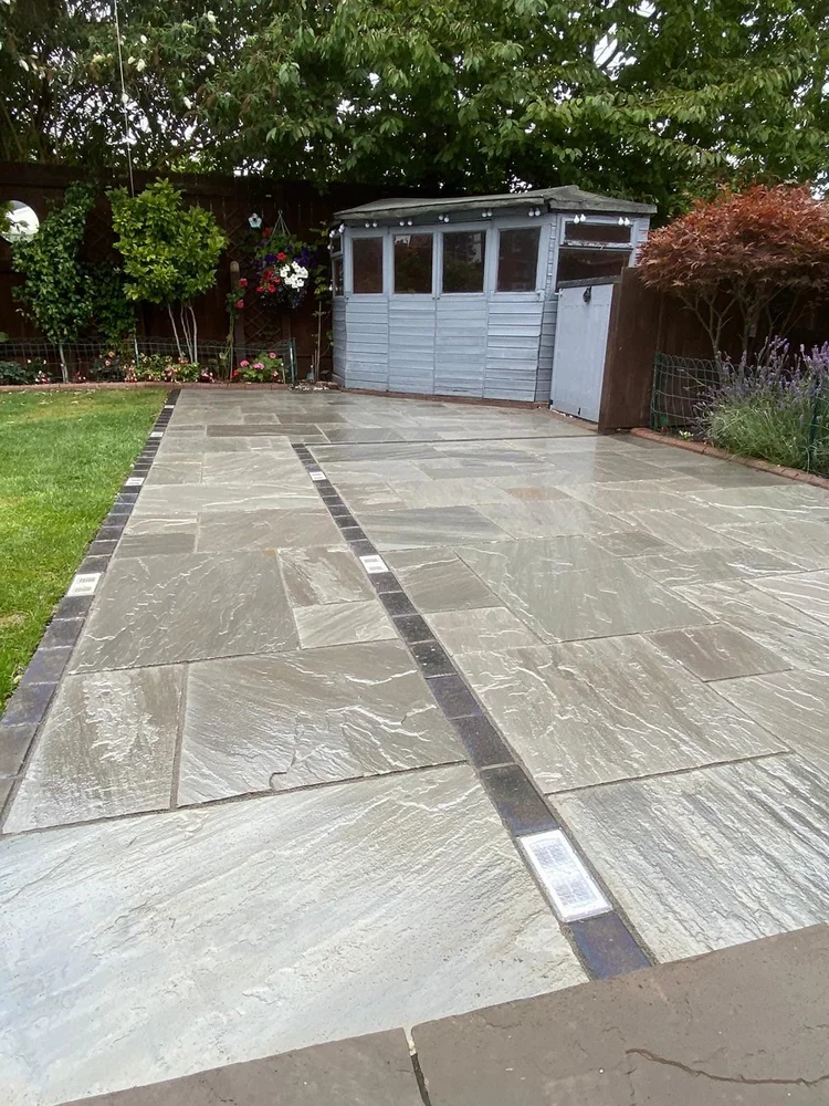 Grey porcelain patio with a light strip and shed base