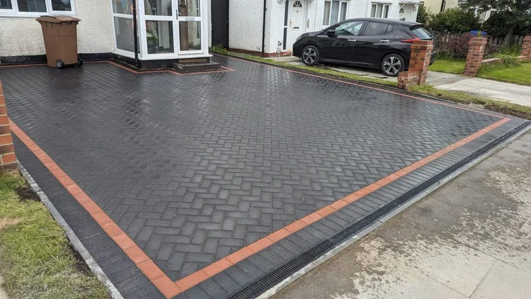 Herringbone block paving with a red soldier-course border