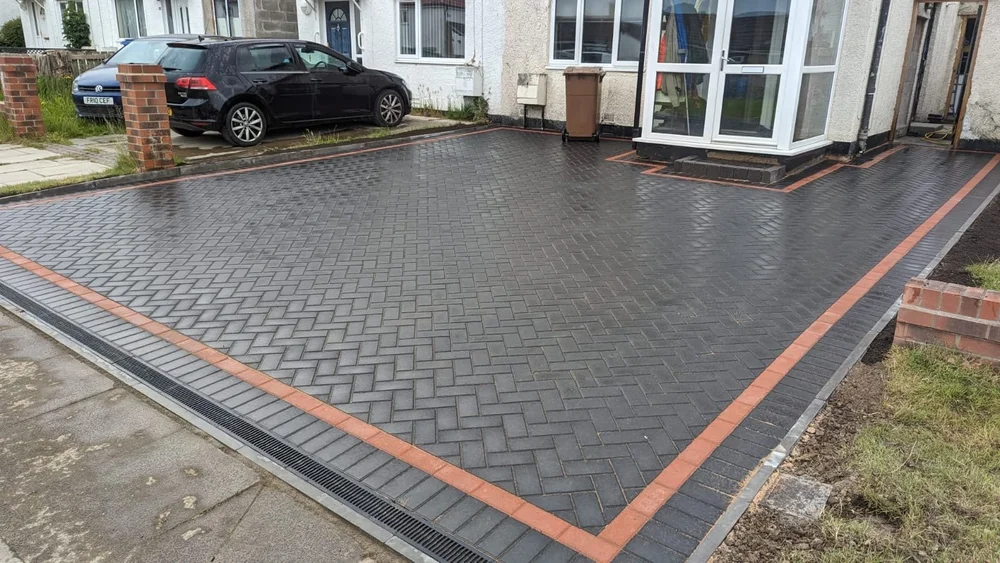 Charcoal herringbone driveway with a red border