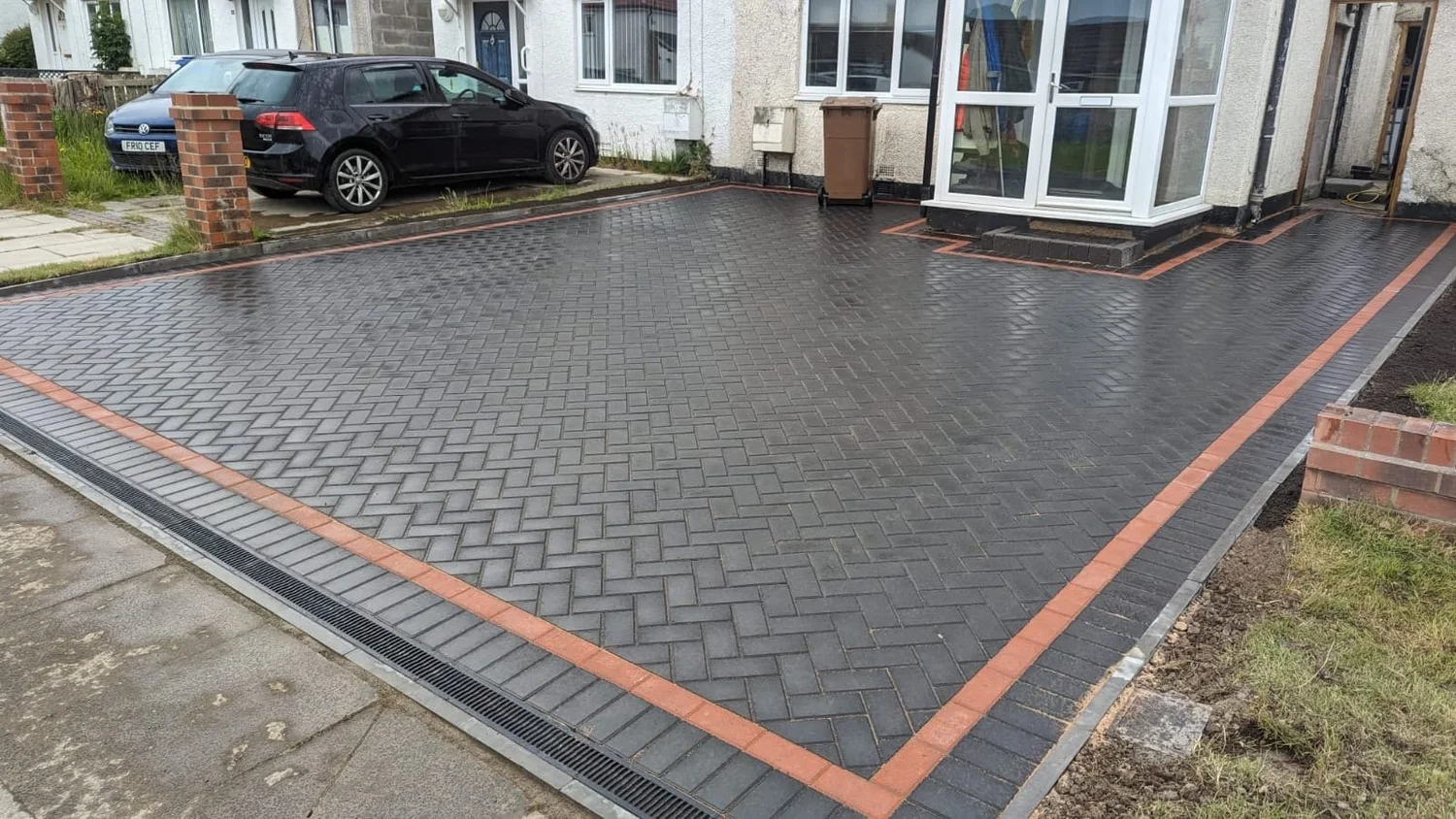 Charcoal herringbone driveway with a red border