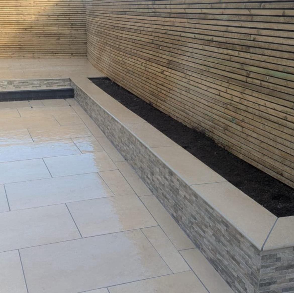 Cream porcelain patio with a split-face raised planter