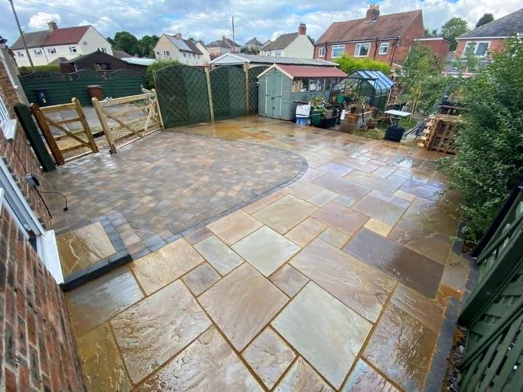Sandstone patio with a curved block-paved feature