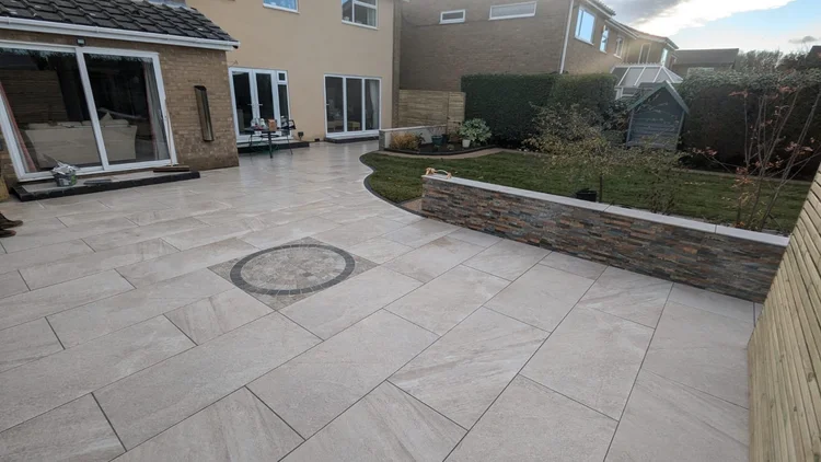 Porcelain patio with a feature drain cover and raised bed