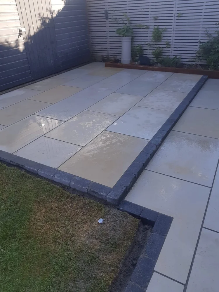 Buff porcelain patio with a charcoal kerb edge