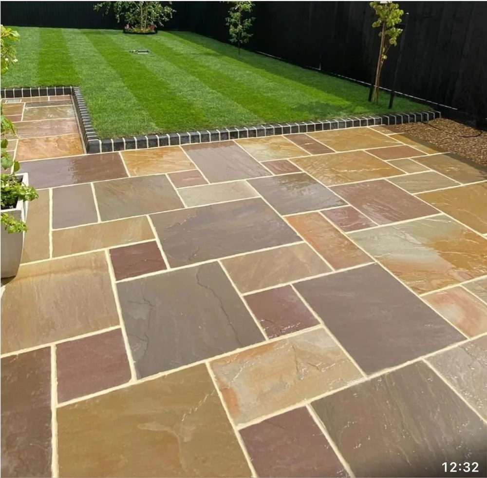 Rainbow sandstone patio with a striped lawn beyond