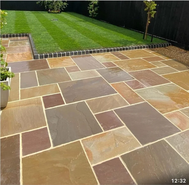 Rainbow sandstone patio with a striped lawn beyond