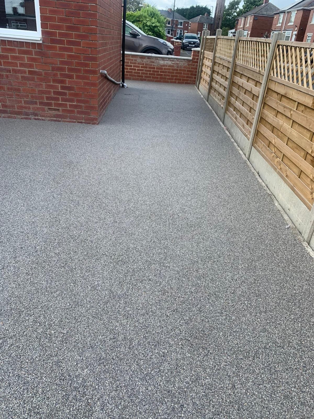 Grey resin side path beside new panel fencing