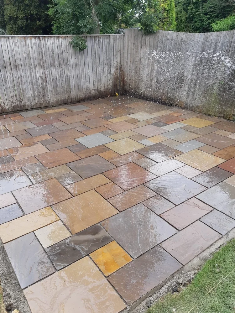 Multi-tone sandstone patio in a fenced garden