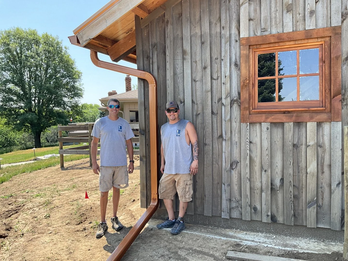 Evan and Ryan, owners of L&L Seamless Gutters, at a finished copper gutter job