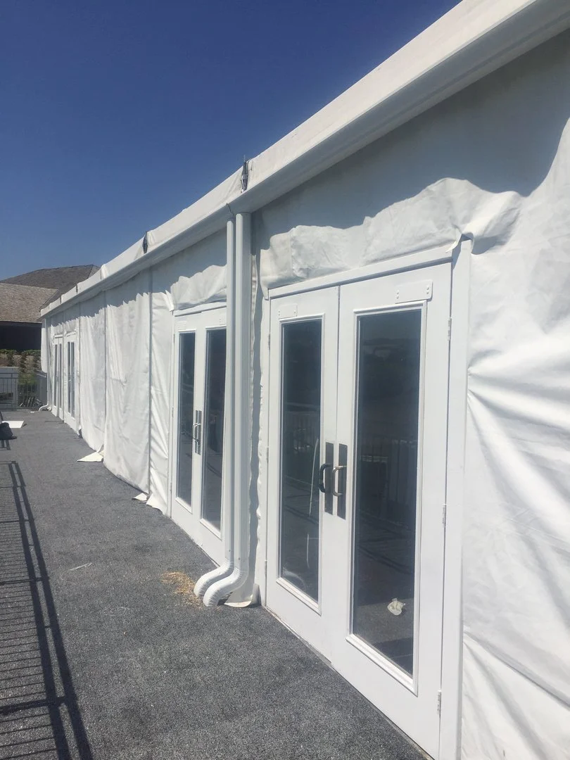 White seamless gutter and downspout on an event tent, close-up
