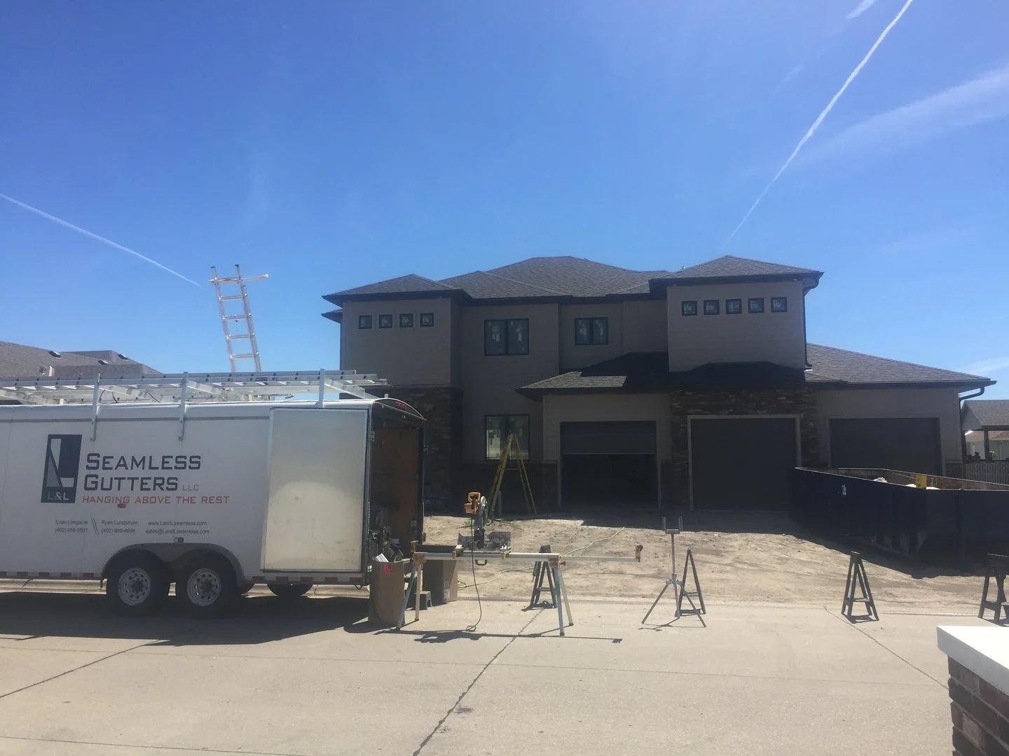 Two-story modern new construction home with L&L trailer out front