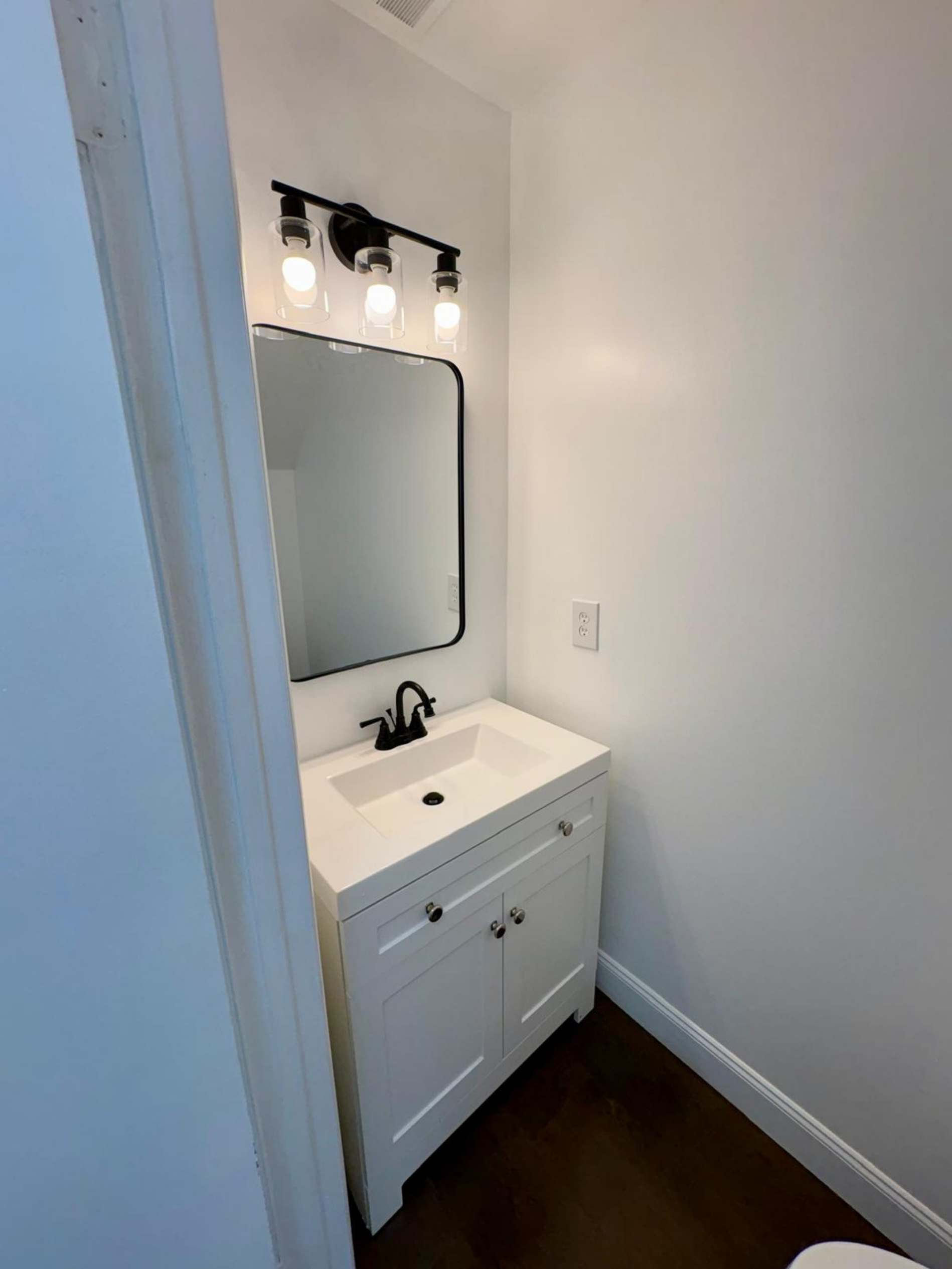 Upgraded with new drywall and paint, vanity, toilet, mirror, and modern lighting.