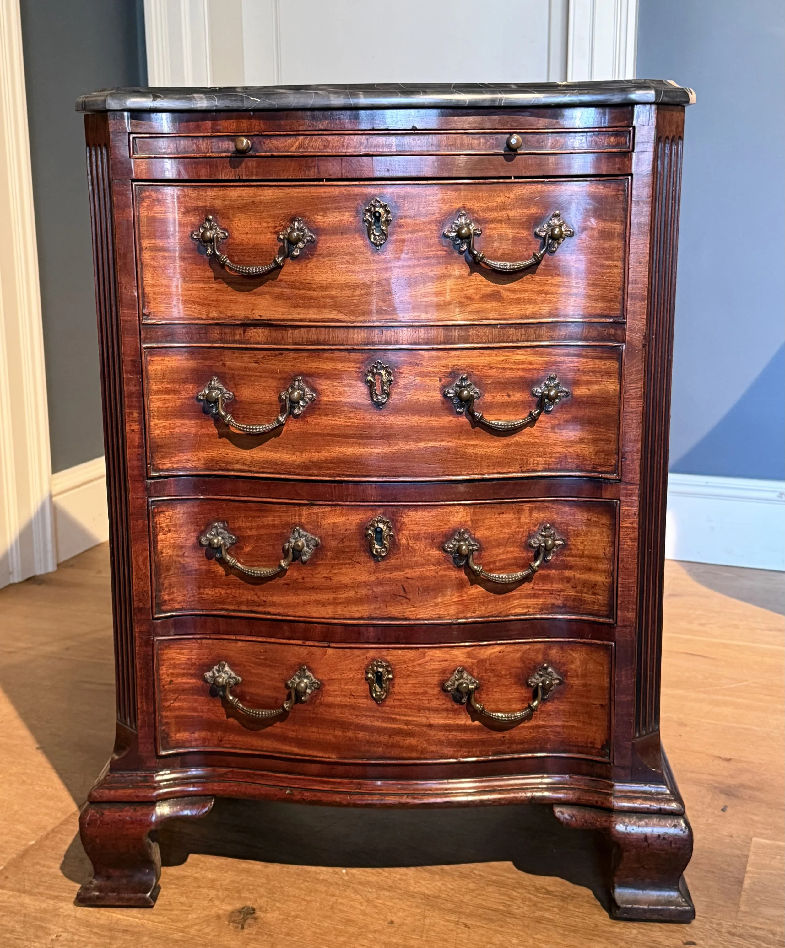 A very small George III marble top serpentine chest of drawers circa 1770