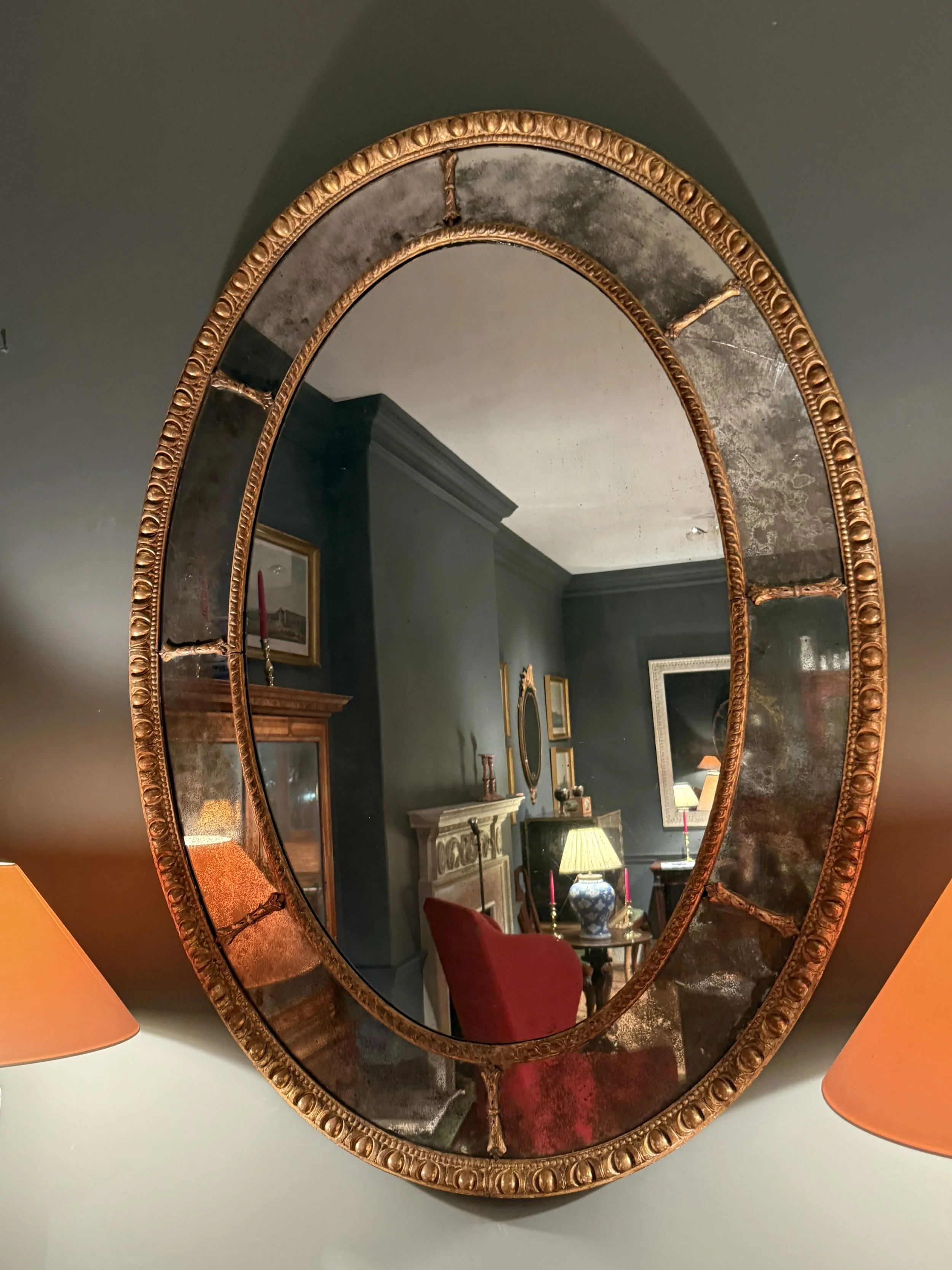 A large oval giltwood mirror circa 1760