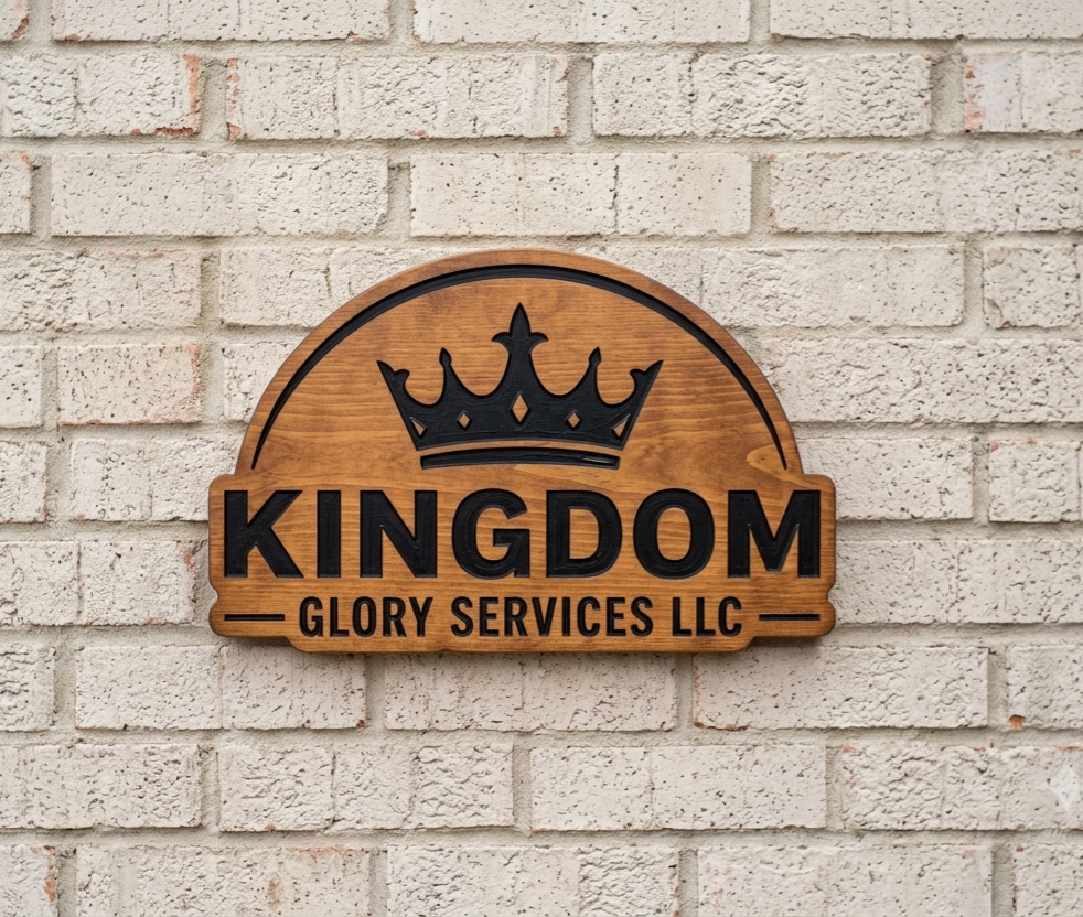 Wooden sign on a brick wall with a crown design and the text 'KINGDOM GLORY SERVICES LLC'.