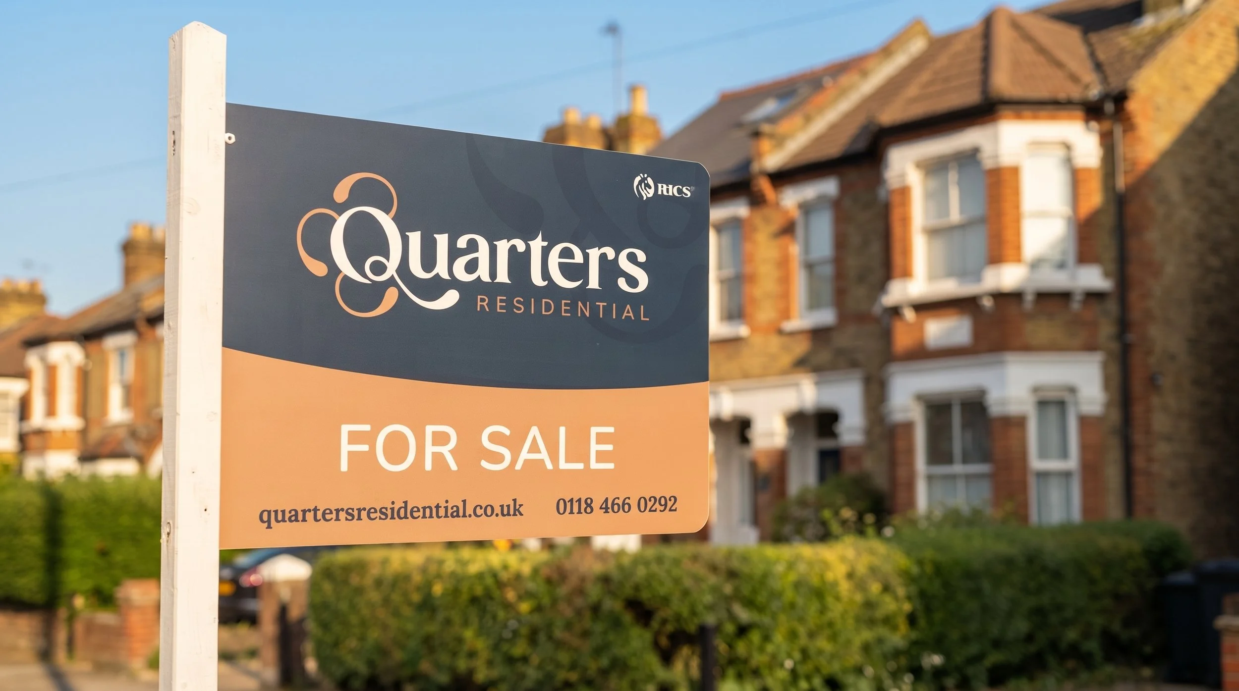 For sale sign in front of a residential building with red brick walls and white window frames.