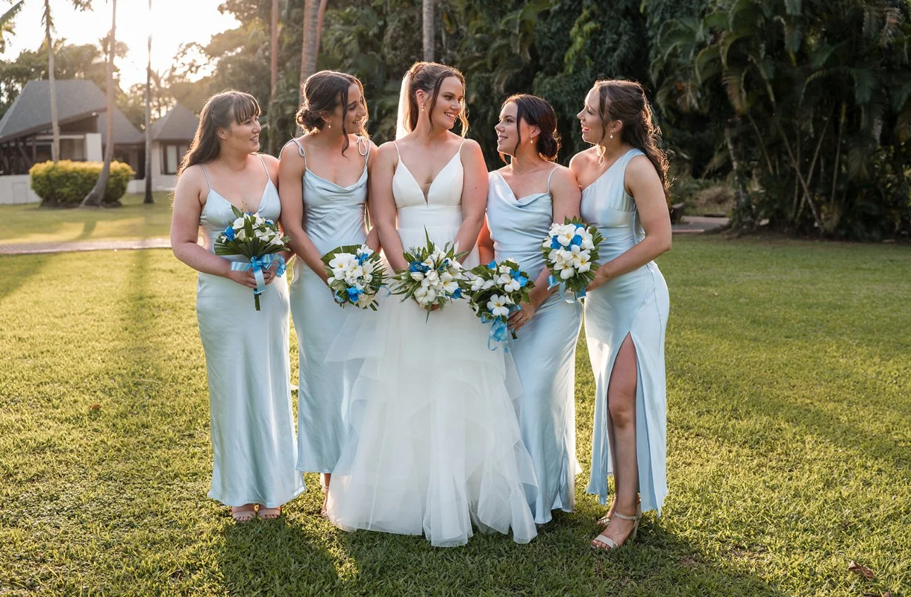 Bride and bridesmaids in blue dresses together at a destination wedding.