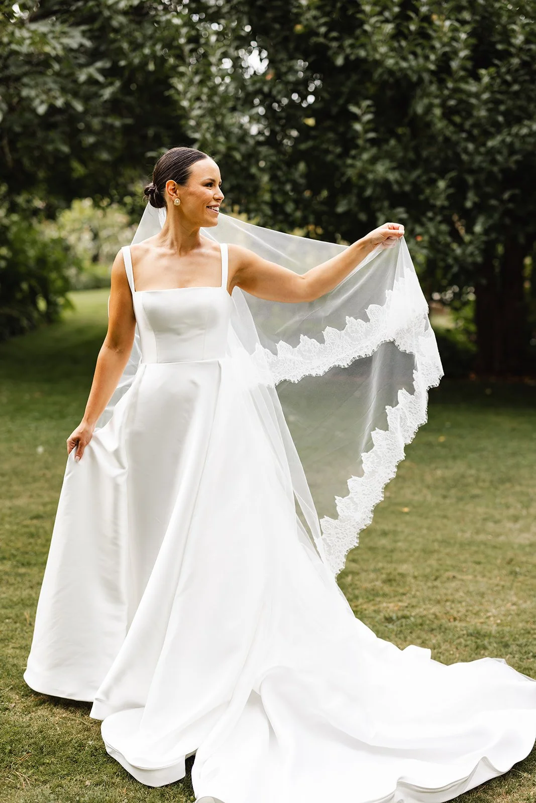Bride outdoors in her wedding dress and veil. 