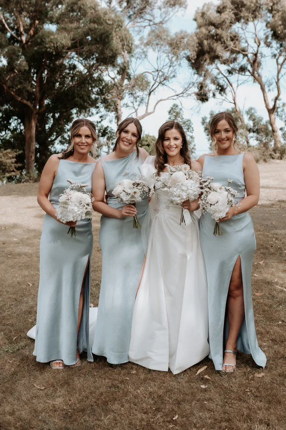 Bride and bridesmaids in blue dresses together on Tasmanian wedding day.