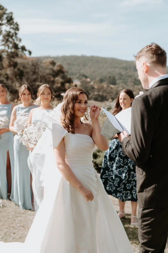 Bride wearing soft bridal makeup during her outdoor wedding ceremony.