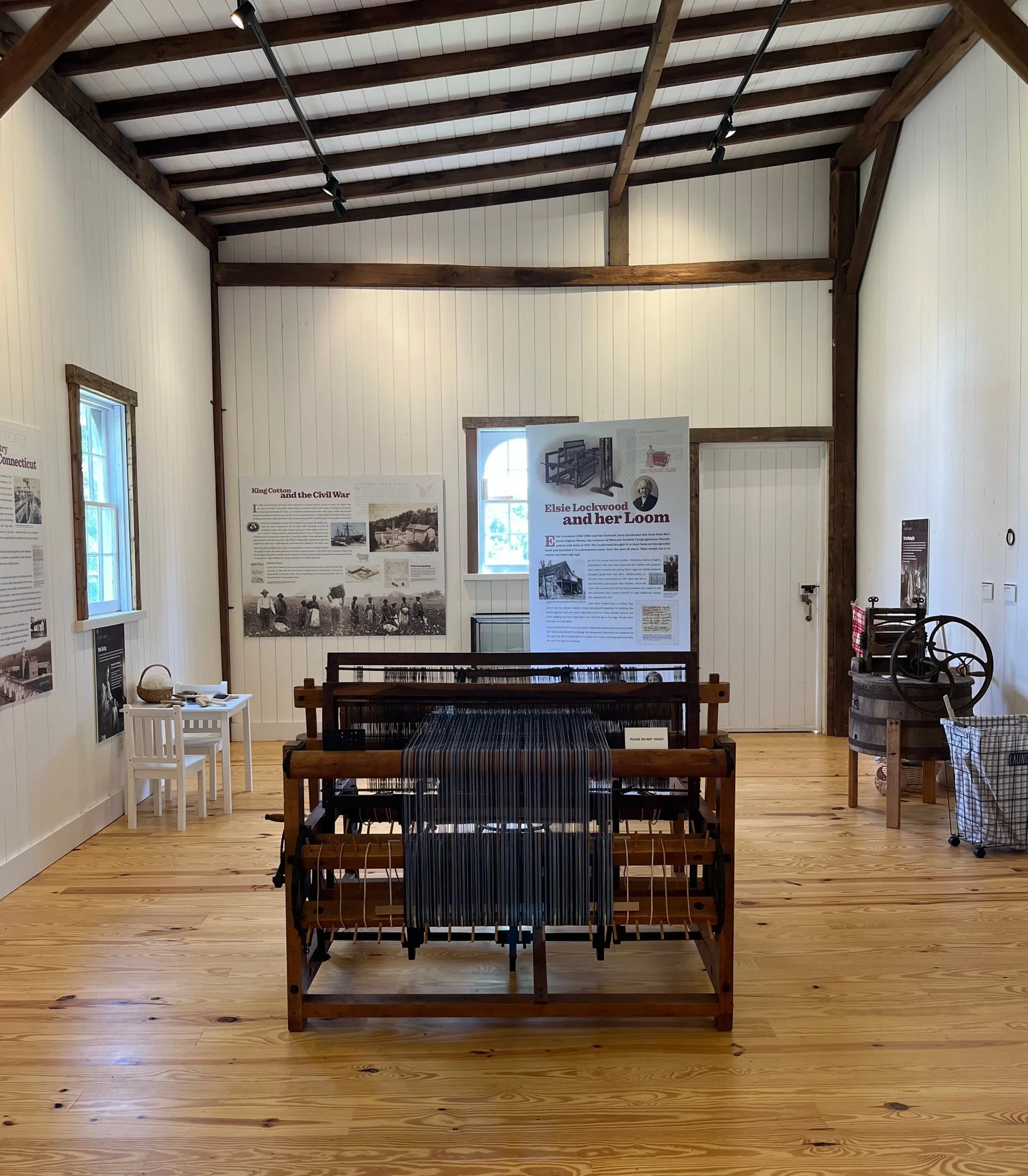 The textile room, with a large floor loom and panels on the walls.