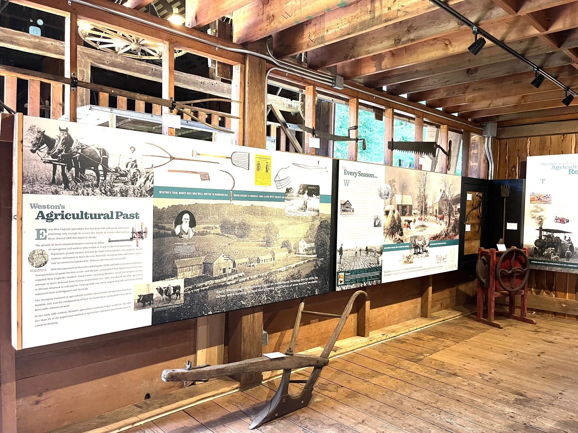 Panels on Weston's agricultural past, with an old wooden plough below.