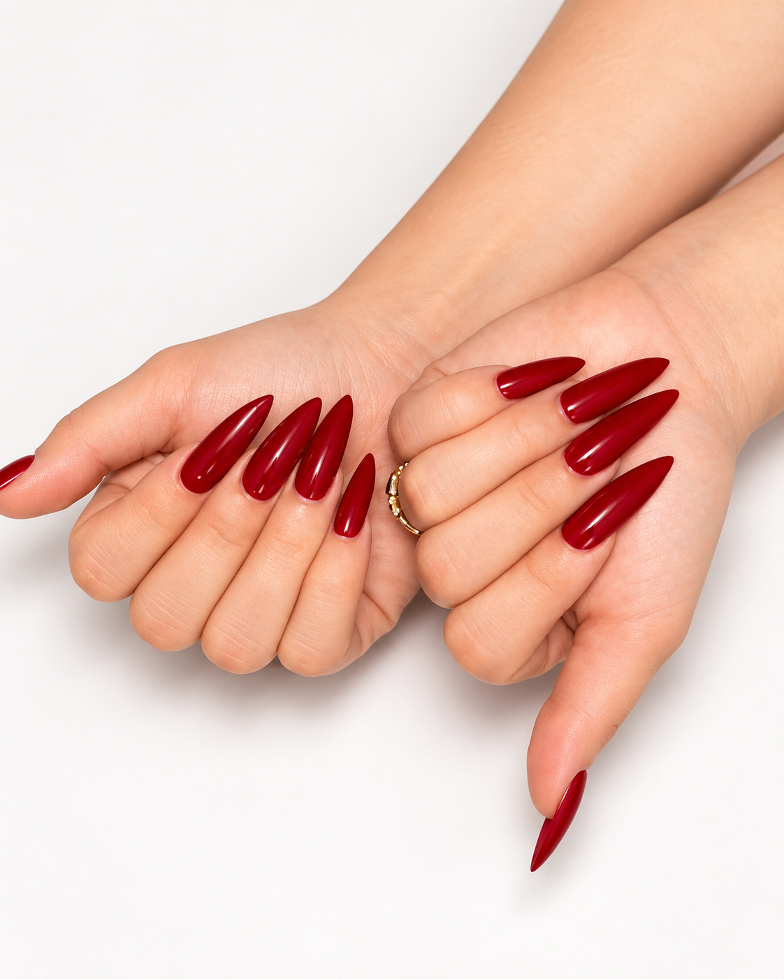 Close-up of a person's hands with long, red, stiletto-shaped nails.