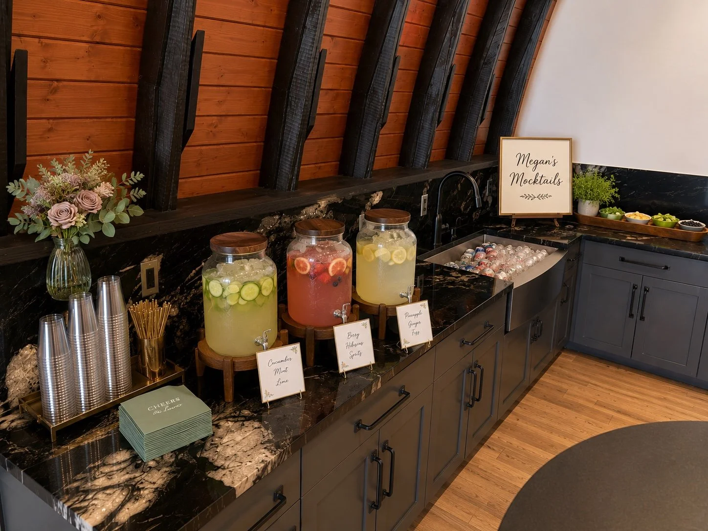 Megan’s Mocktails station with colorful drinks, fresh garnishes and flowers.