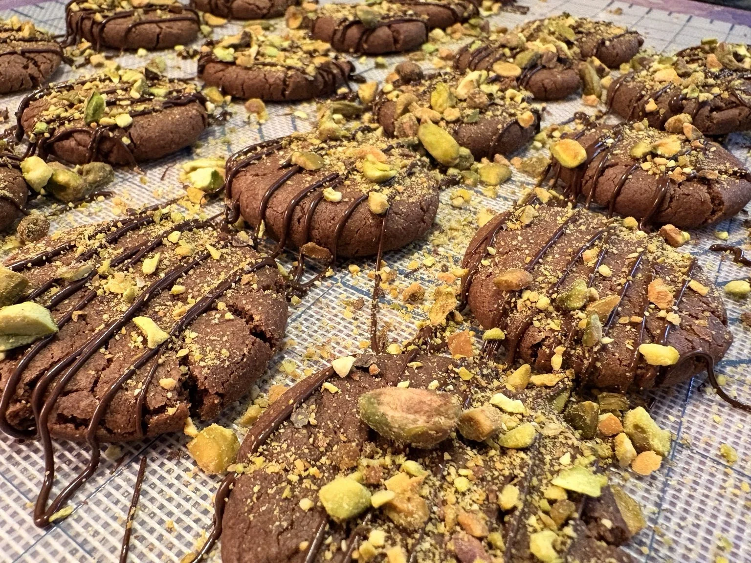 Chocolate pistachio cookies finished with a chocolate drizzle.