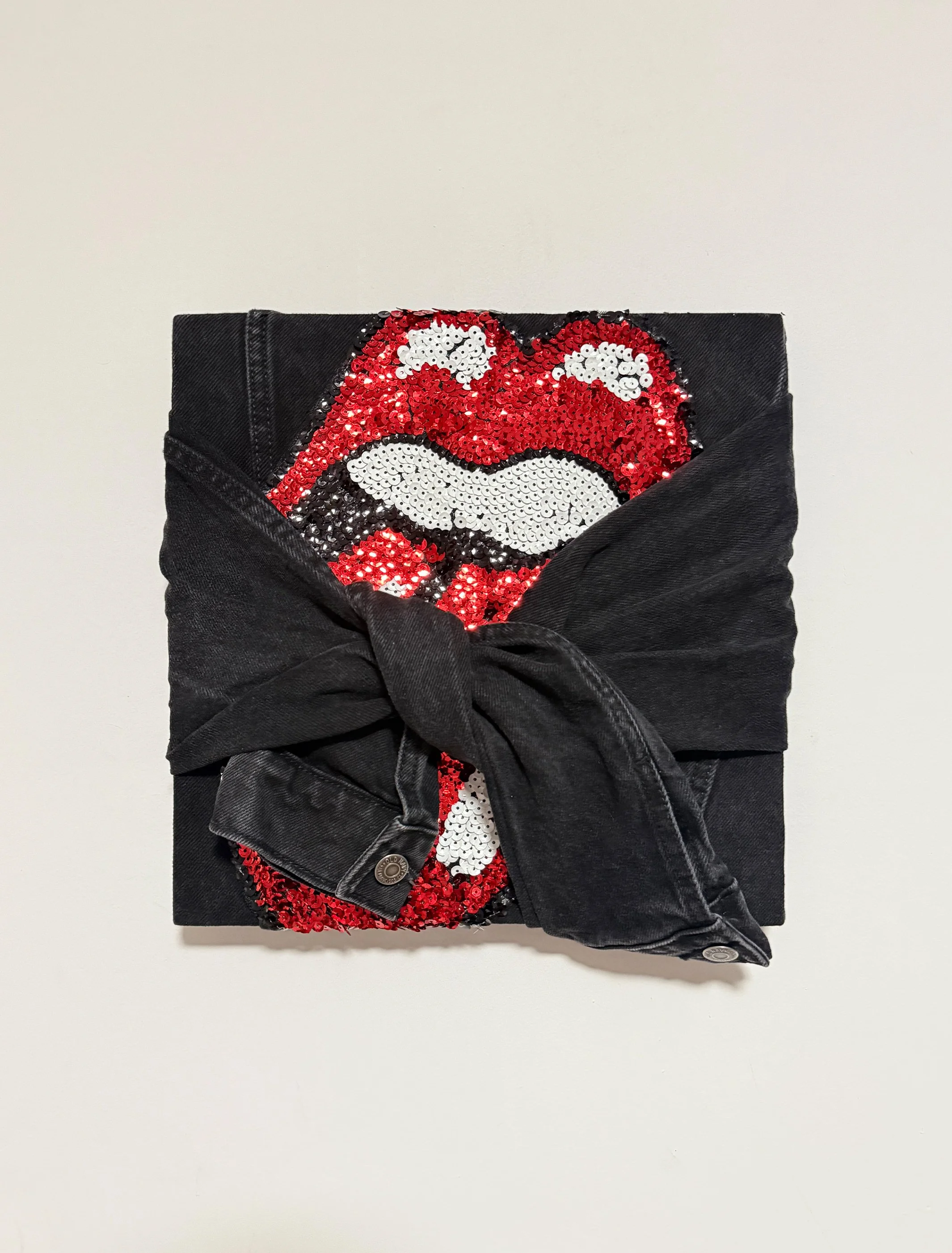 Licker, 2026. Old Navy Rolling Stones sequin denim jacket stretched on wood panel. 12 in. x 12 in.

