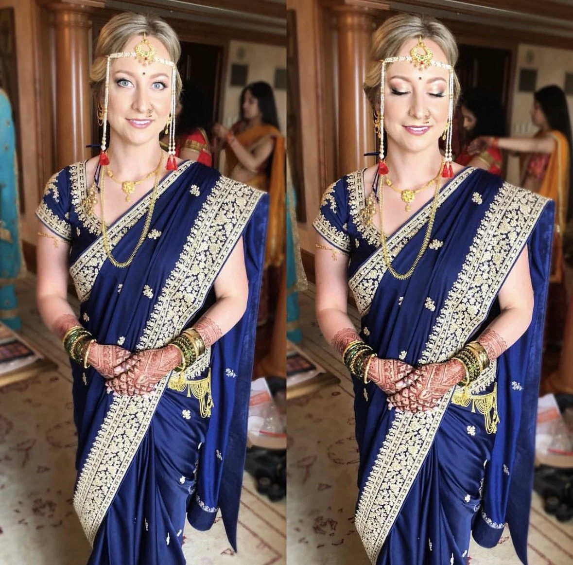 A woman dressed in traditional Indian attire, wearing a blue sari with gold embroidery and jewelry, including necklaces, bangles, and a headpiece, standing indoors.