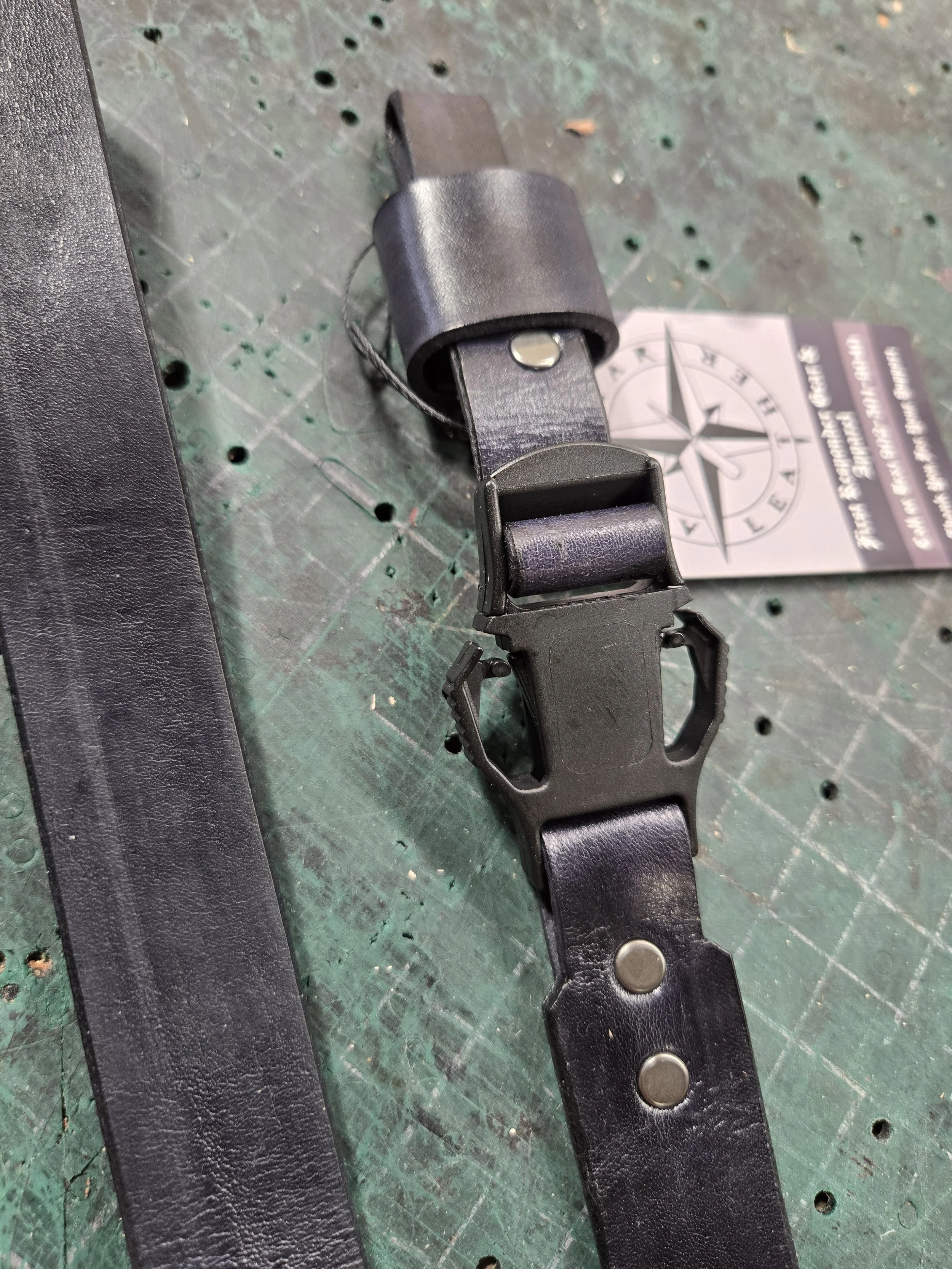 Handcrafted black leather firefighter helmet chin strap with adjustable hardware and quick-release buckle.