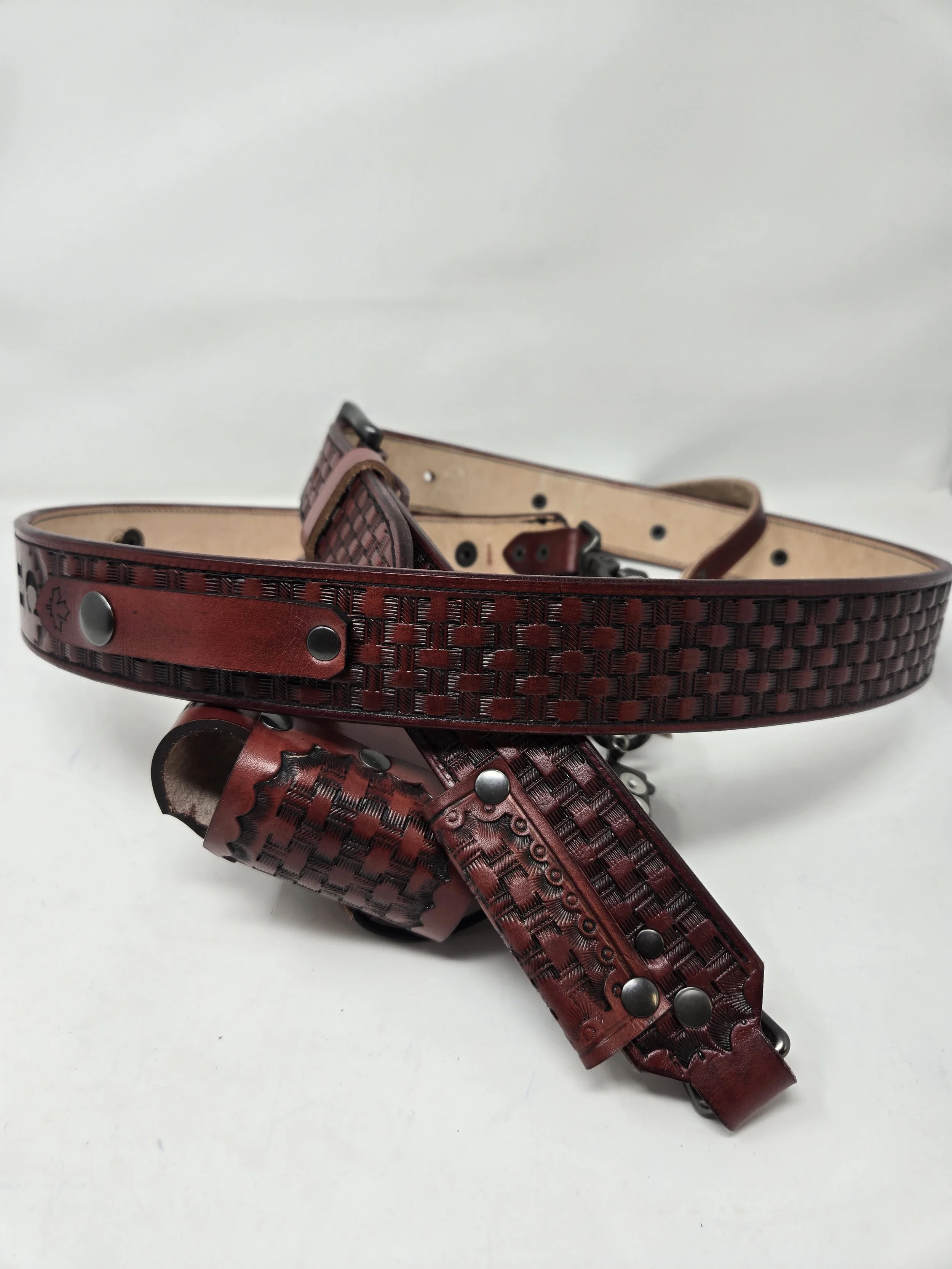 Custom red leather radio harness components with decorative tooling and metal hardware by Awl Star Leather.