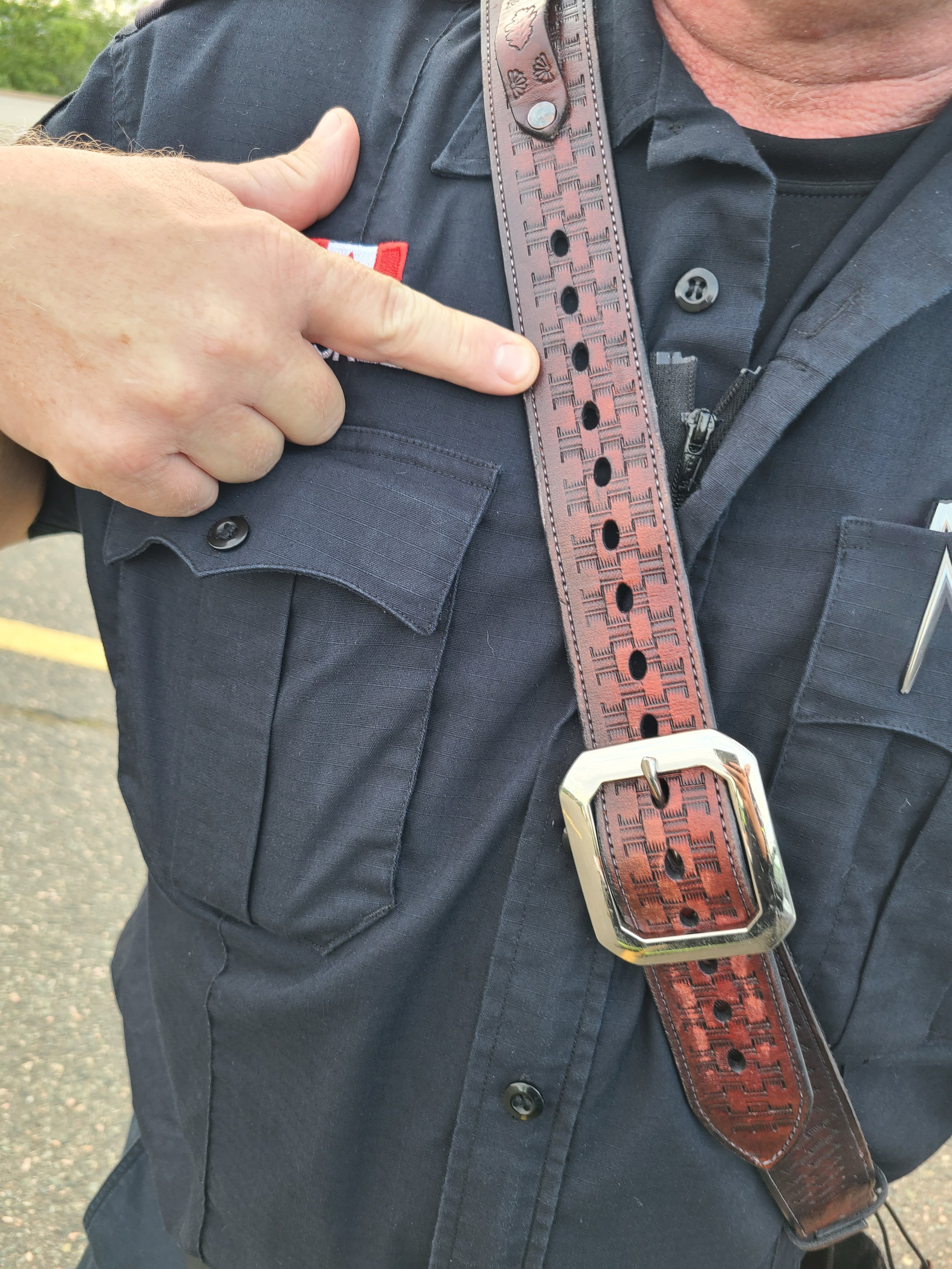 Awl Star Leather radio harness being worn, showing personalized leather engraving on the shoulder strap.