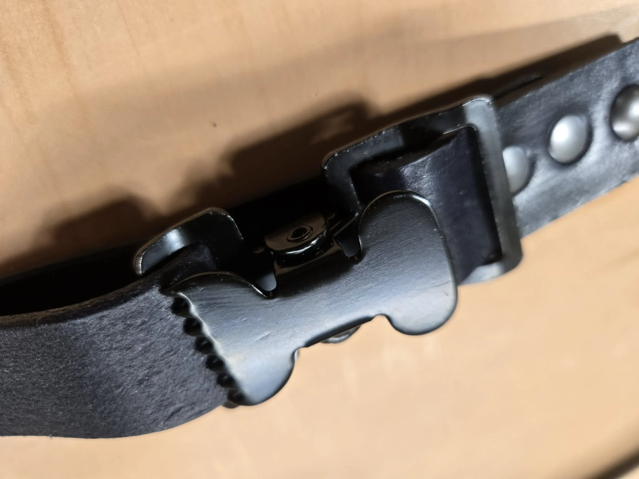 Close-up of the quick-release buckle and hardware on an Awl Star Leather firefighter helmet chin strap.