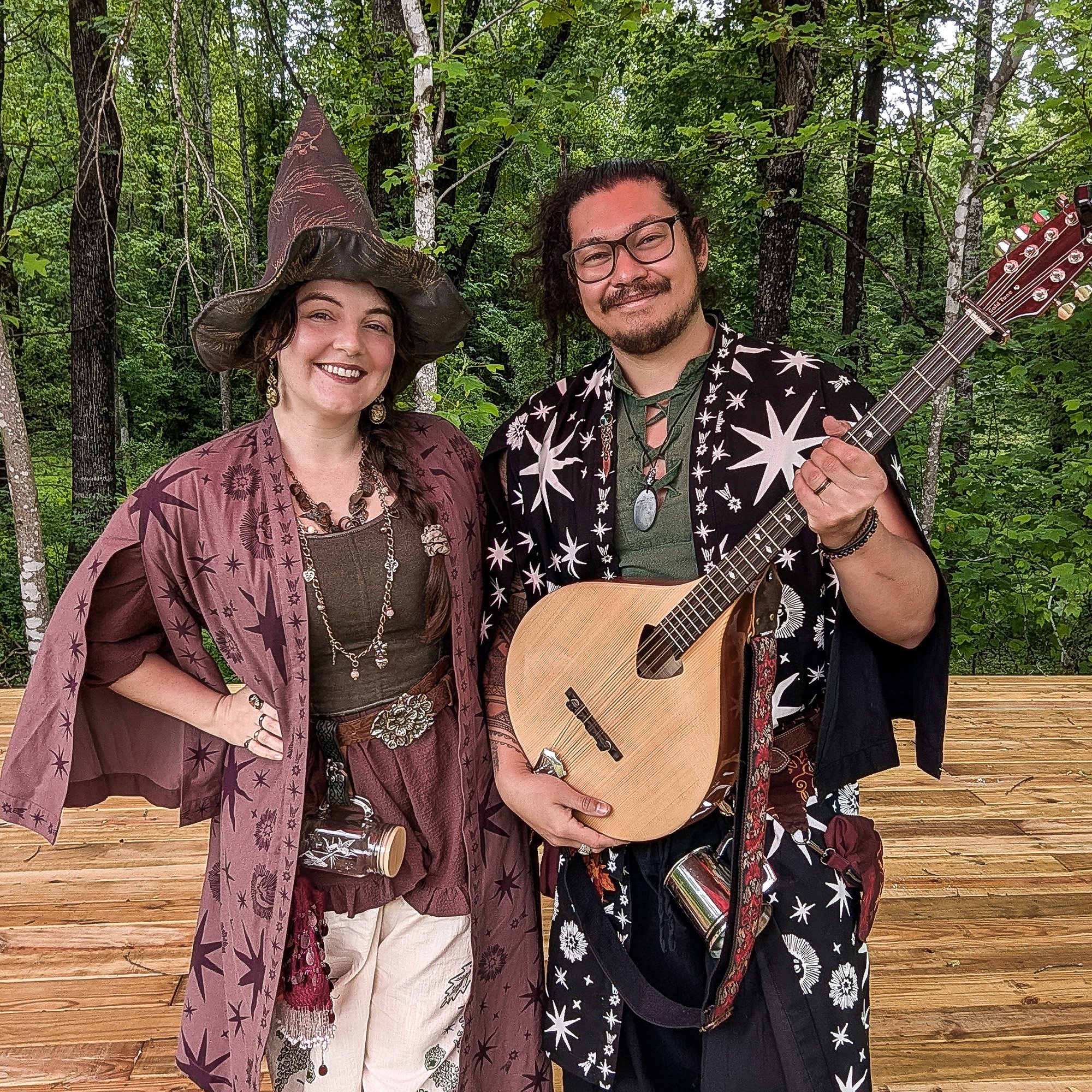 Picture of the band Secret Moss Meadow. They are wearing Fantasy/Renaissance fair outfits and holding an Irish Bouzouki.