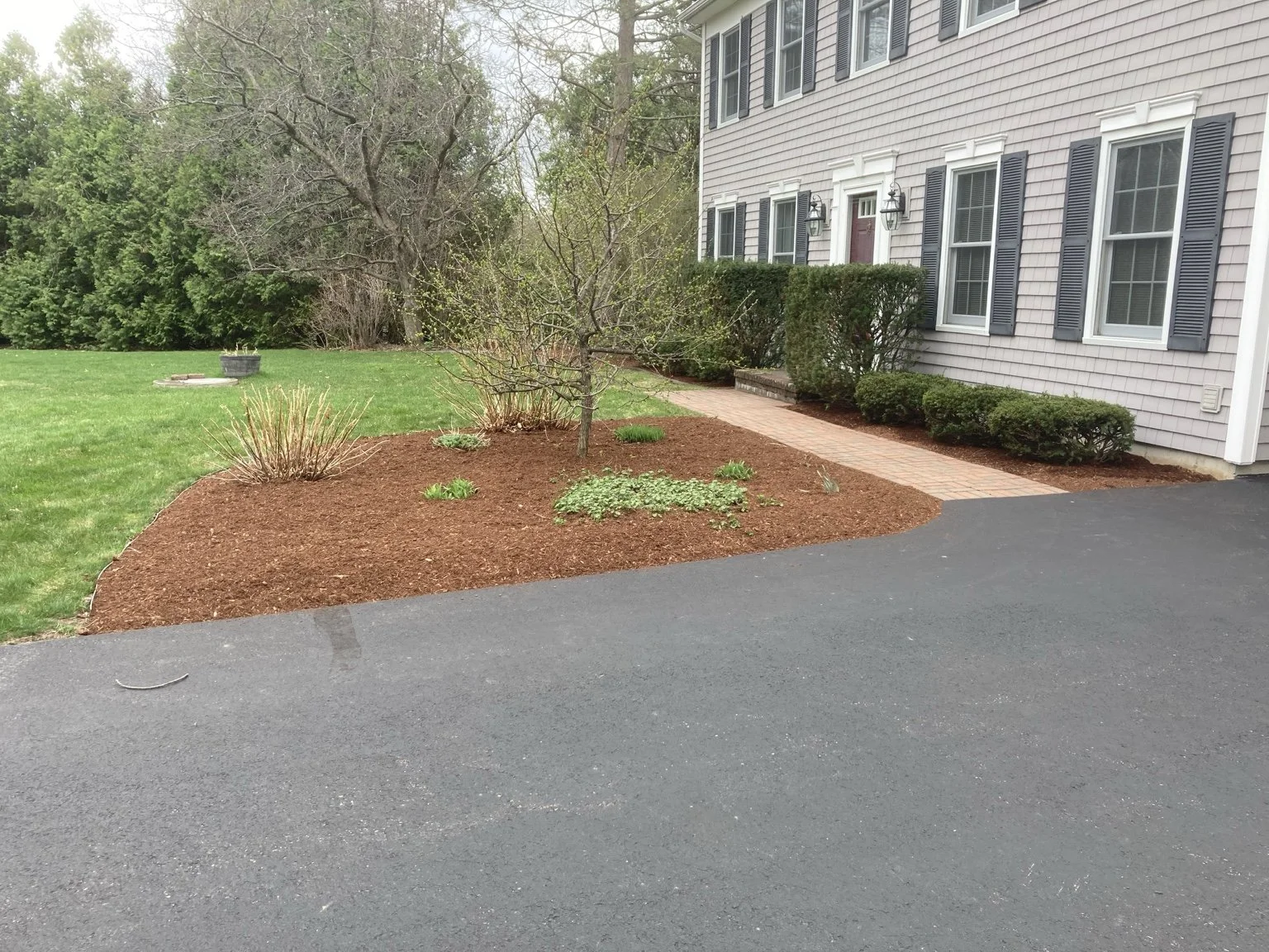 Finished landscape mulch bed maintained by Catamount Mowing