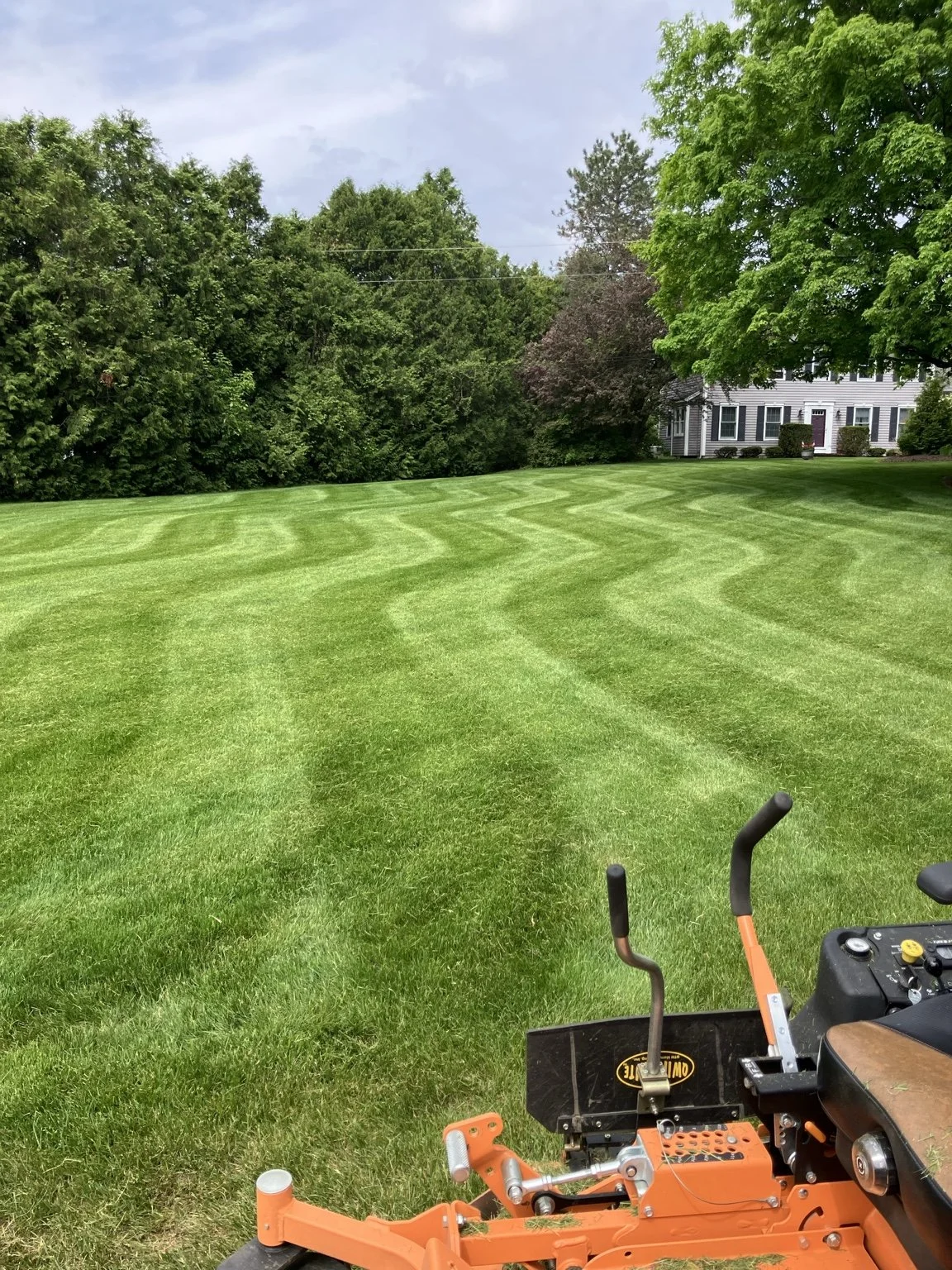 Striped residential lawn maintained by Catamount Mowing in Colchester, Vermont