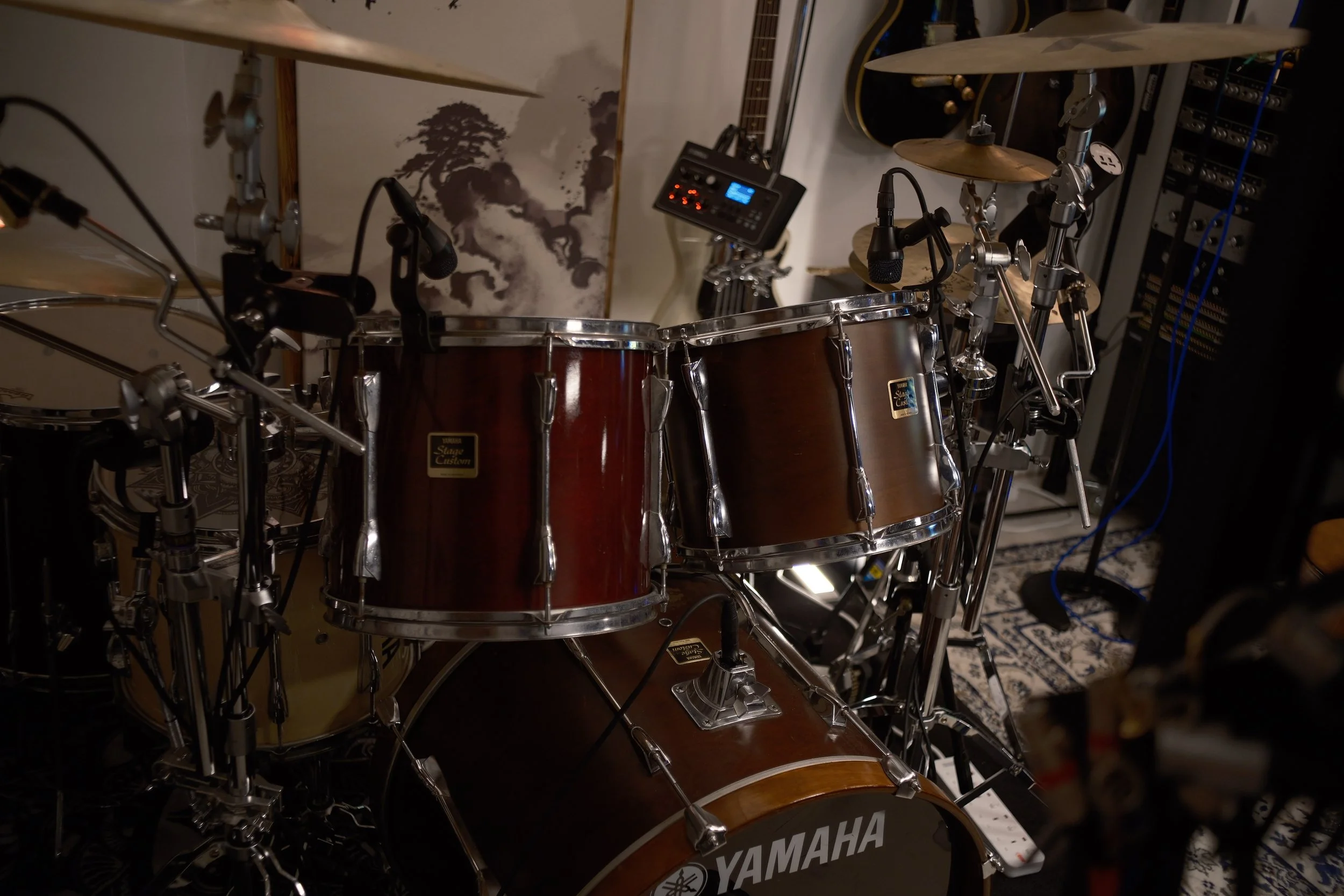 A Yamaha electronic drum set with various cymbals, drums, and microphones in a music studio or room.