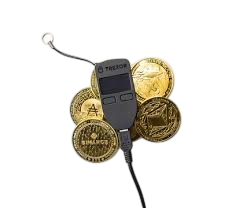Bitcoin and cryptocurrency coins along with a TREZOR hardware wallet and a USB security key.