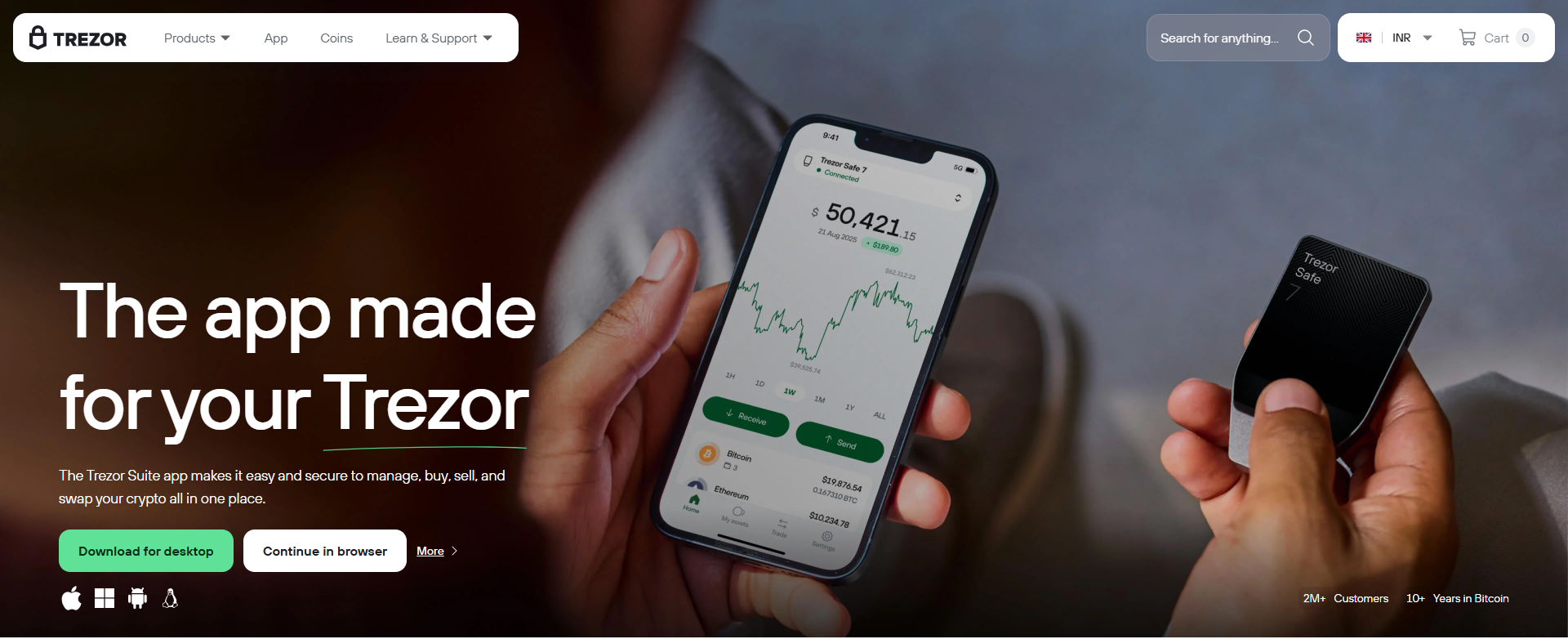 Person holding a smartphone displaying a cryptocurrency portfolio with a green line graph and portfolio value, with a Trezor hardware wallet in the other hand.