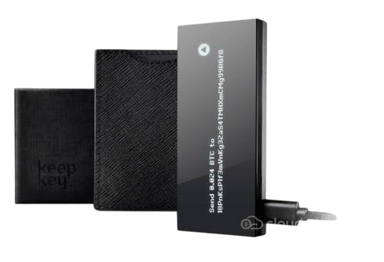 A digital teleprompter device with a screen displaying text, mounted on a stand, with a black case and a remote control device beside it.