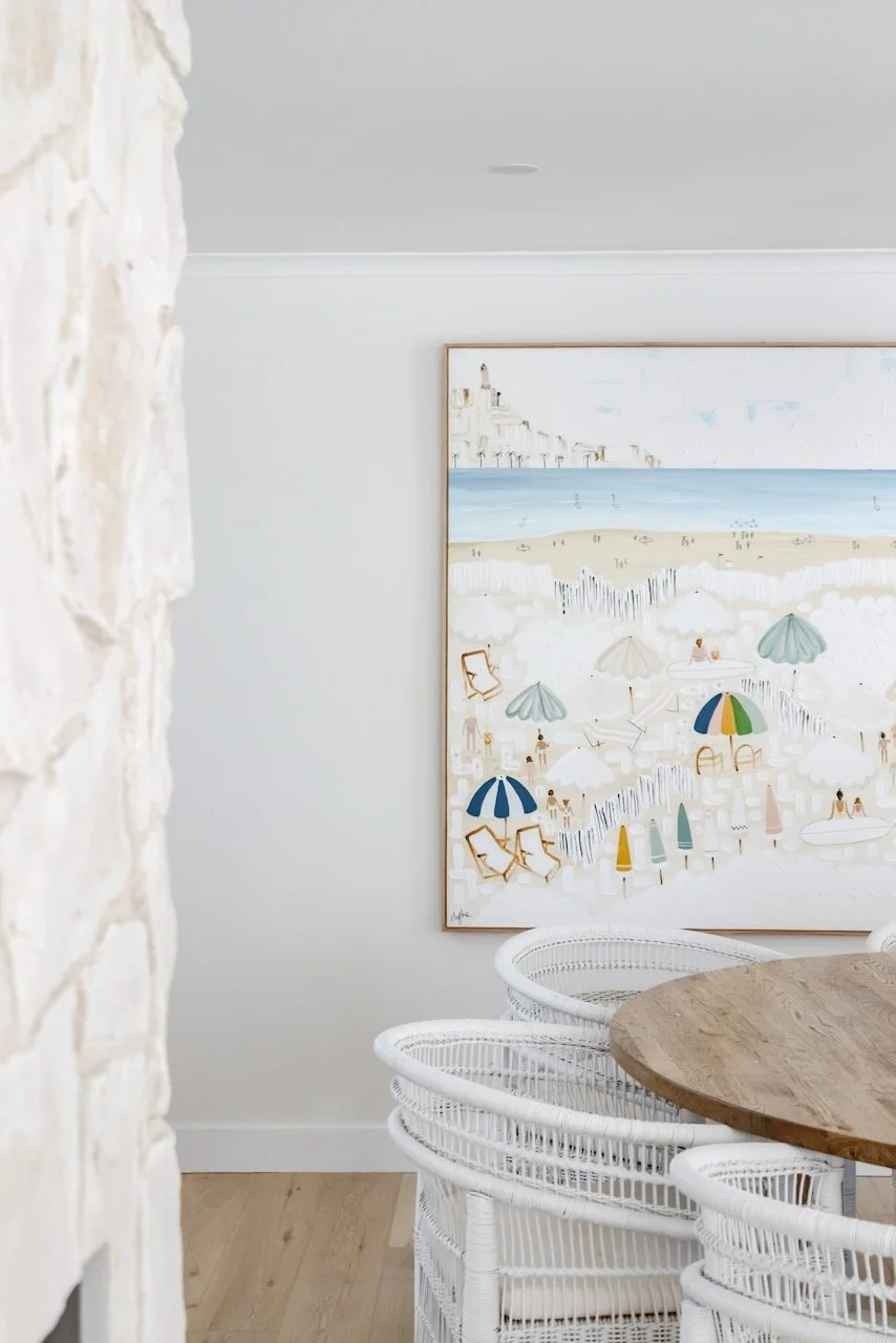 Beach scene painting with umbrellas, lounge chairs, and people on the shore, near white fence and ocean in background.