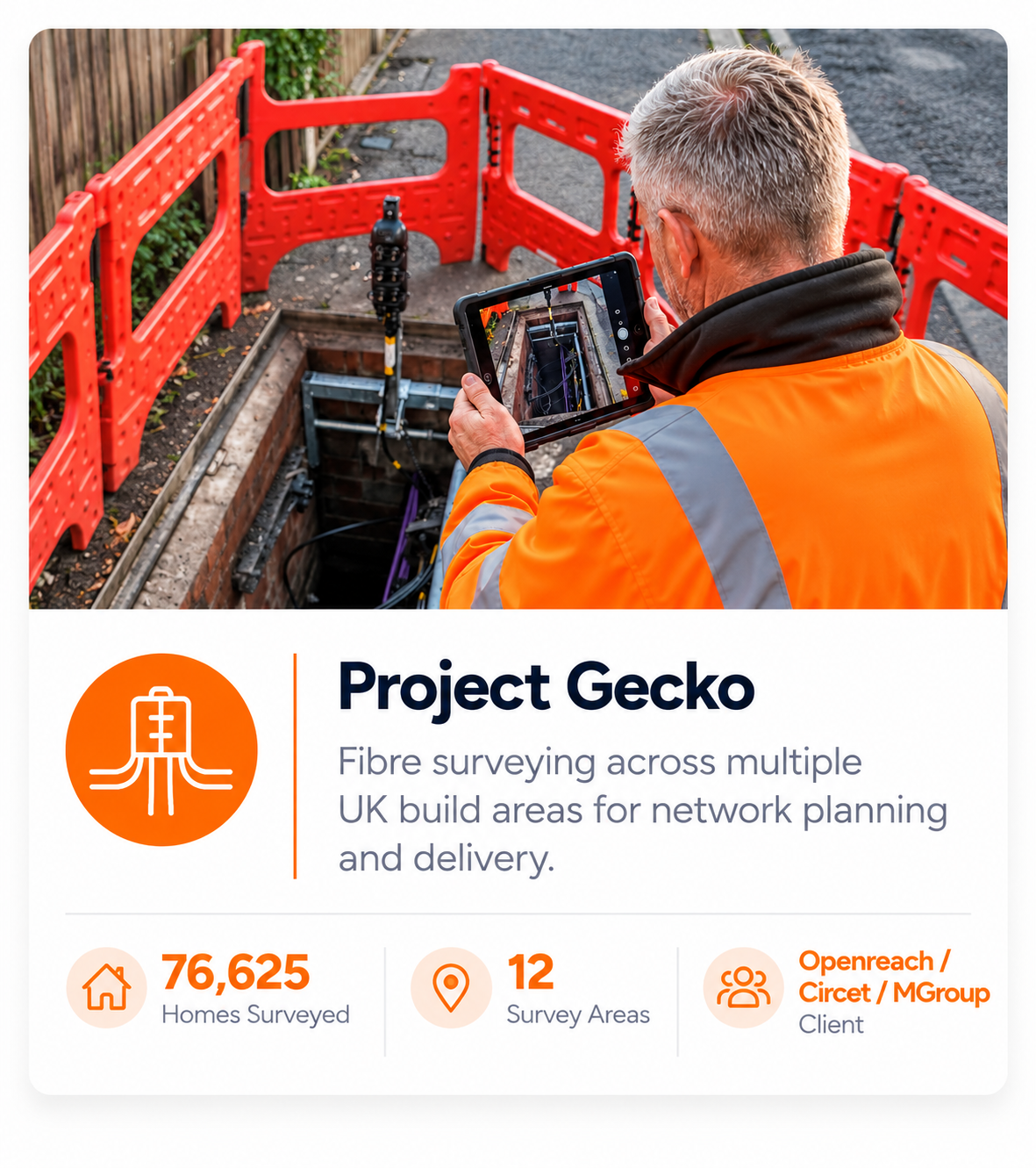 A worker in an orange safety jacket is taking a photo with a tablet of a fiber optic survey in an open trench, surrounded by orange safety barriers.