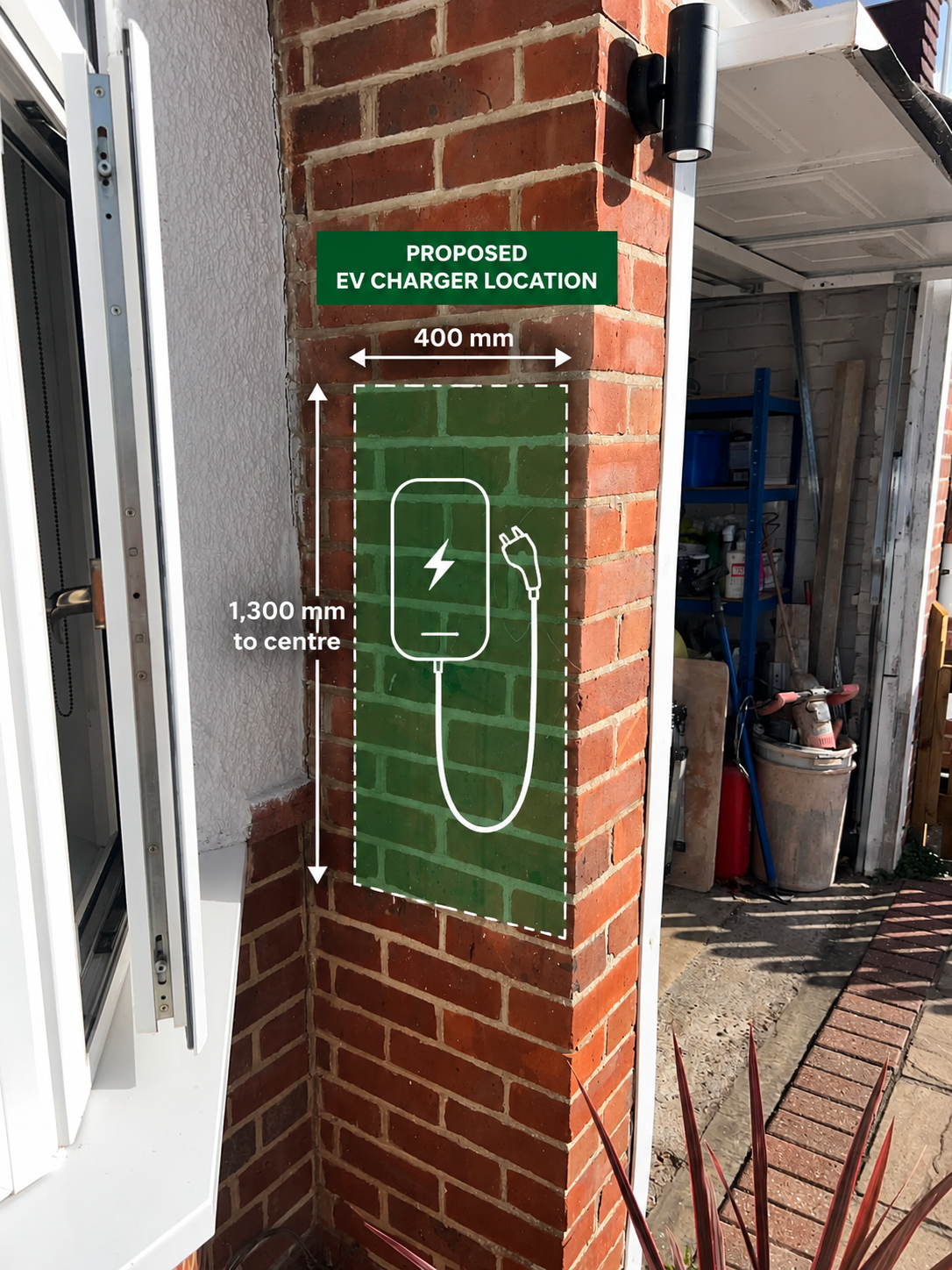 Sign indicating a proposed EV charger location on a brick wall with dimensions for positioning, including a graphic of an electric vehicle charger and cable.