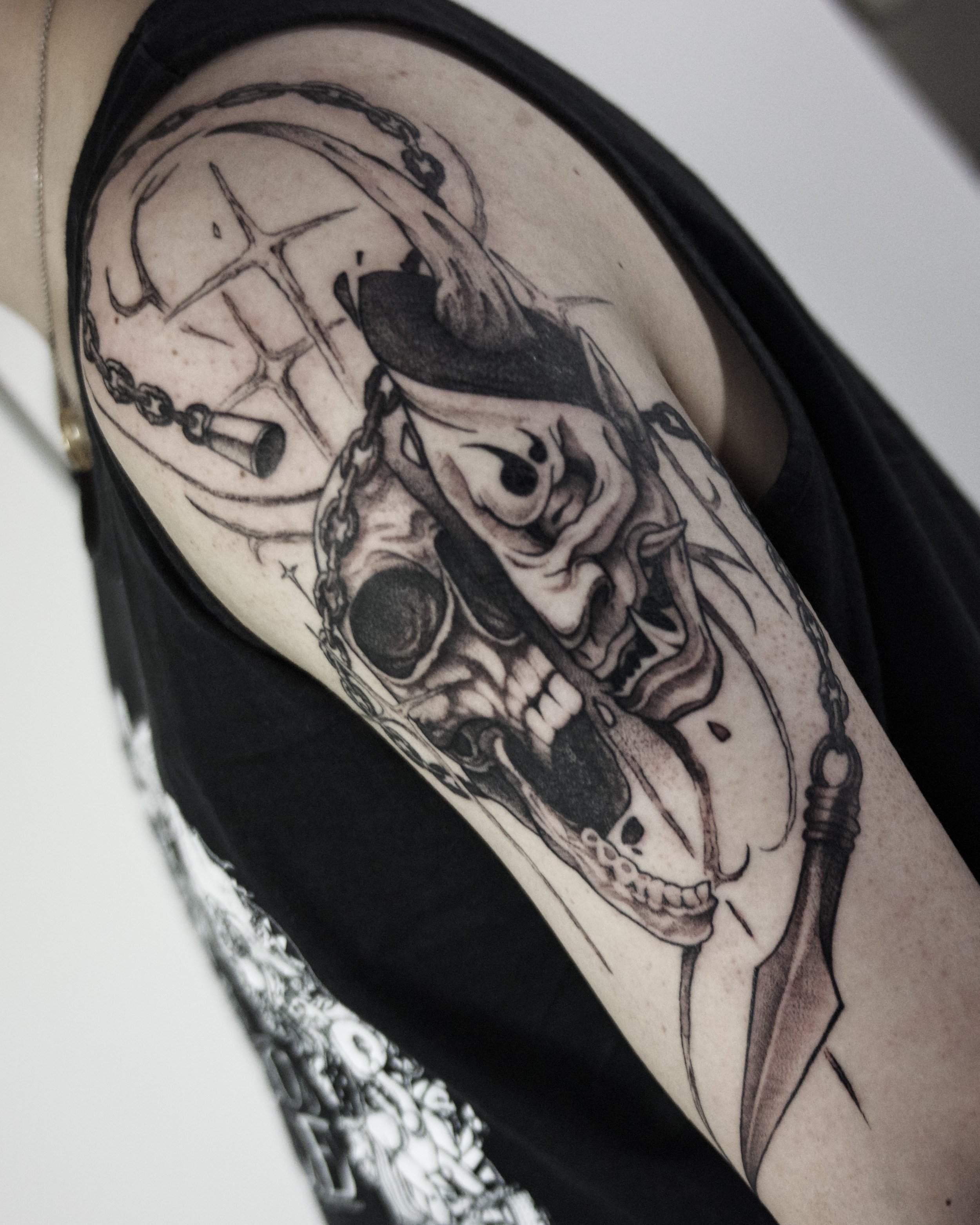 Tattoo of a skull with chains on a person's arm.