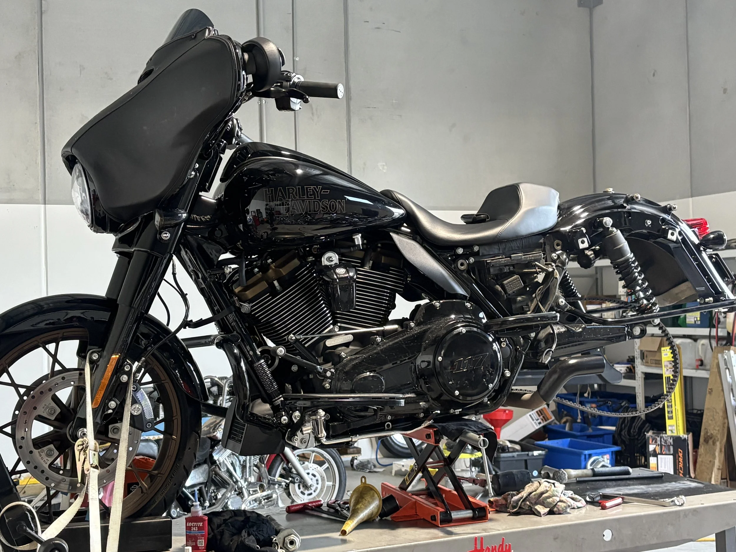 2022 Harley-Davidson FLHXST Street Glide ST on a workshop hoist with its rear wheel removed, undergoing an ABS bleed using TechnoResearch Centurion Super Pro diagnostic equipment.