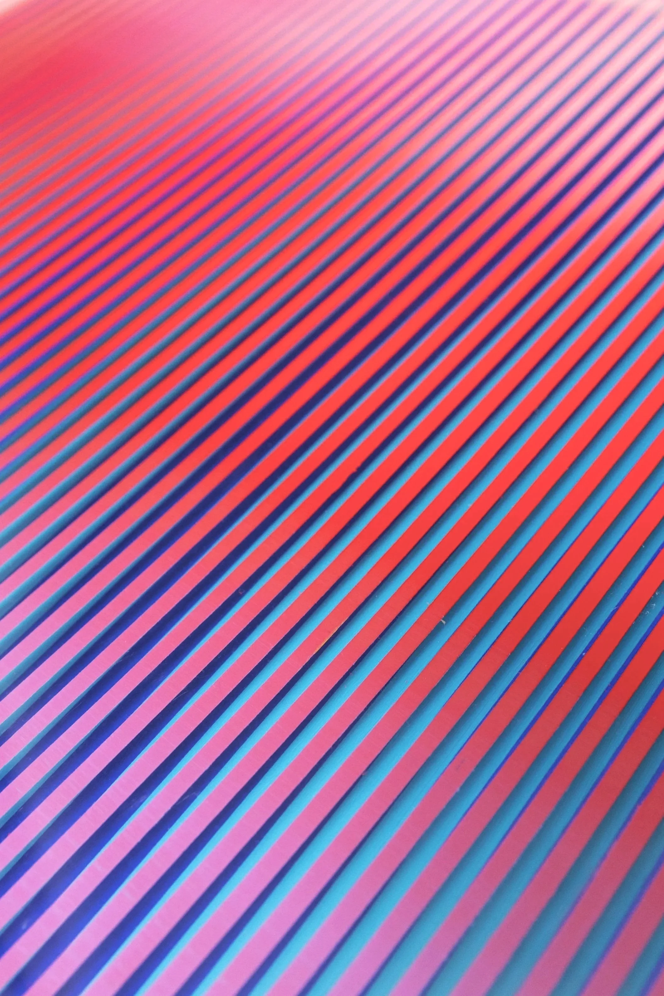 Close-up of a colorful surface with diagonal pink, orange, blue, and purple stripes.