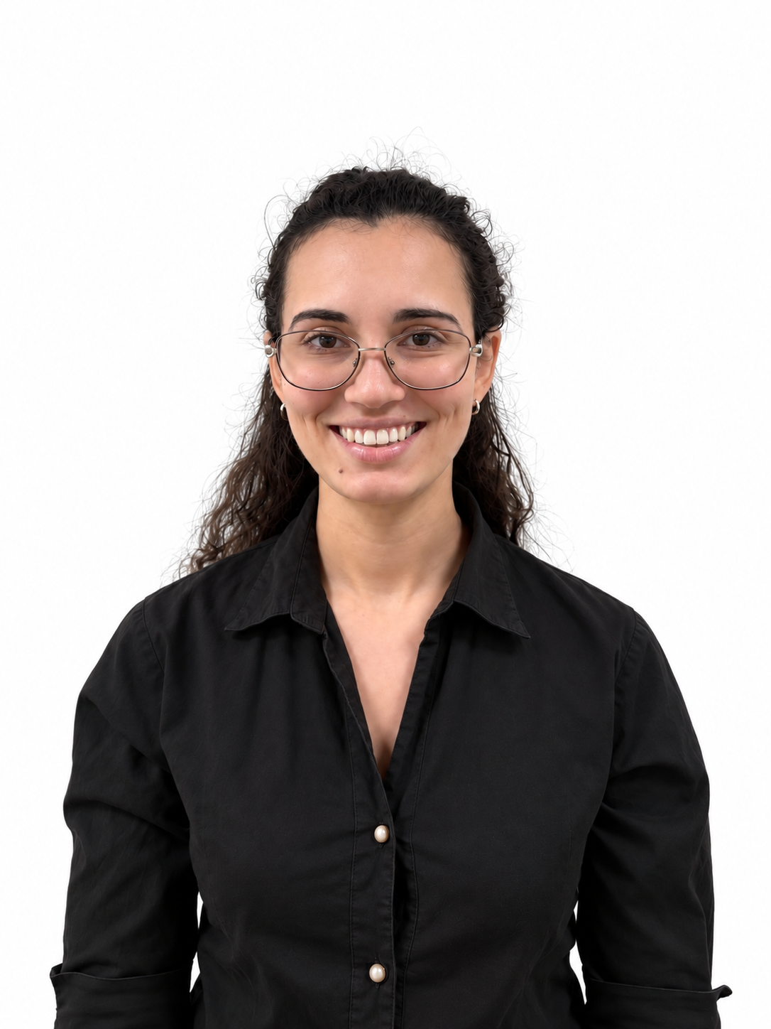 A young woman with curly brown hair, wearing glasses and a black button-up shirt, smiling against a white background.